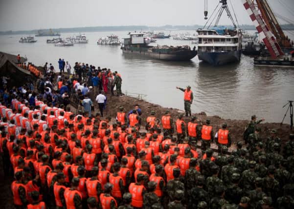Soldiers and rescue workers pay their respects to victims during a memorial service in front of the Chinese cruise ship in Jianli. Picture: AFP