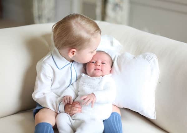 Prince George cradles his little sister Princess Charlotte. The photograph was taken by the Duchess of Cambridge in mid-May at Anmer Hall. Picture: PA