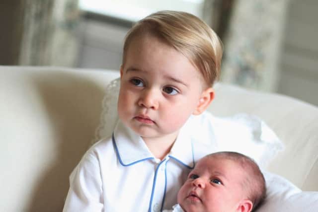 Prince George cradles his little sister Princess Charlotte. The photograph was taken by the Duchess of Cambridge in mid-May at Anmer Hall. Picture: Getty