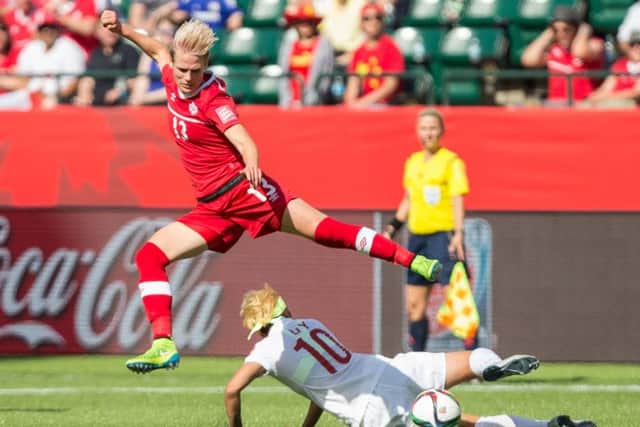 Canada's Sophie Schmidt leaps over China's Li Ying during the opening match of the FIFA Women World Cup. Picture: Getty