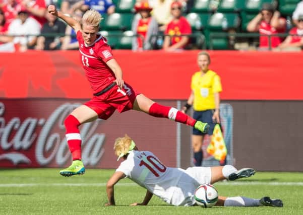 Canada's Sophie Schmidt leaps over China's Li Ying during the opening match of the FIFA Women World Cup. Picture: Getty