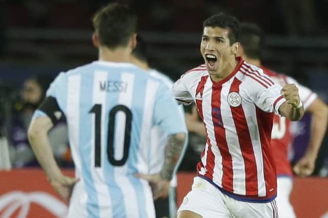 Paraguays Marcos Caceres, back, celebrates team-mate Lucas Barrioss late equaliser. Picture: AP Photo