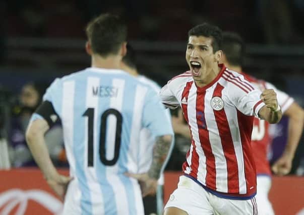 Paraguays Marcos Caceres, back, celebrates team-mate Lucas Barrioss late equaliser. Picture: AP Photo