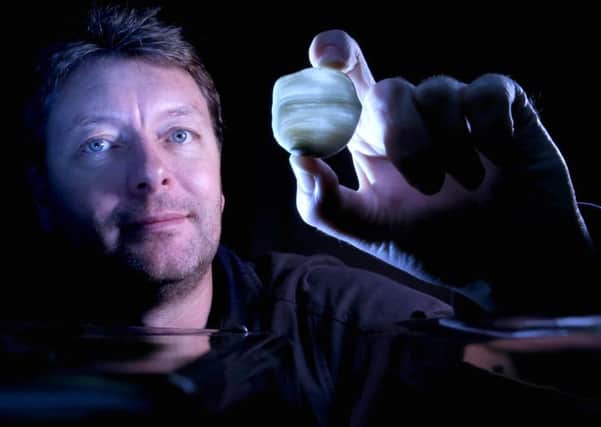 Professor Andy Baker with a fragment of one of the stalagmites. Picture: UNSW Australia