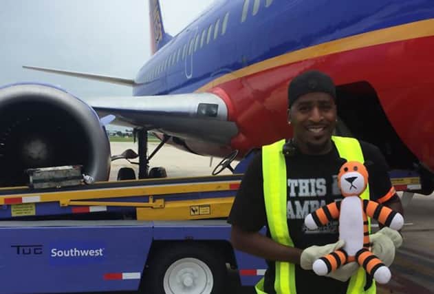 An airport worker gets a helping paw from Hobbes on the apron. Picture: Tampa International Airport