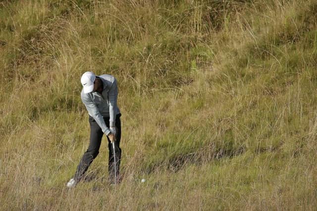 Rory McIlroy hits from the rough as the world No 1 attempted to get to grips with the tough lay-out. Picture: AP