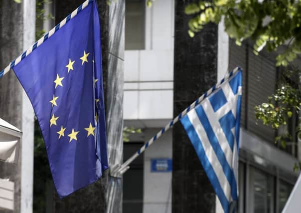 The Greek and EU flags fly in Athens, but the unity is at breaking point  Picture: AP