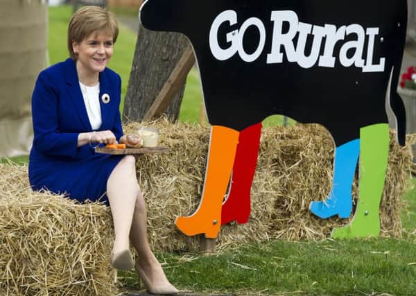 First Minister Nicola Sturgeon enjoys a sample of produce during a visit to the Go Rural  stand. Picture: Ian Rutherford