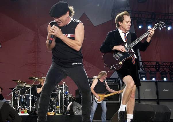 Angus Young, right  wearing his traditional schoolboy outfit on stage with Brian Johnson  has kept it in the family and called upon his nephew Stevie to play with the band. Picture: AP