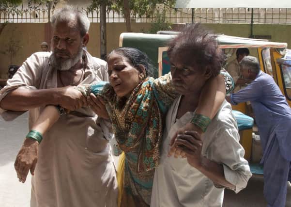Relatives take a woman suffering from heatstroke to hospital in Karachi. Hundreds of mainly elderly people have died as temperatures soared to 45C. Picture: AP