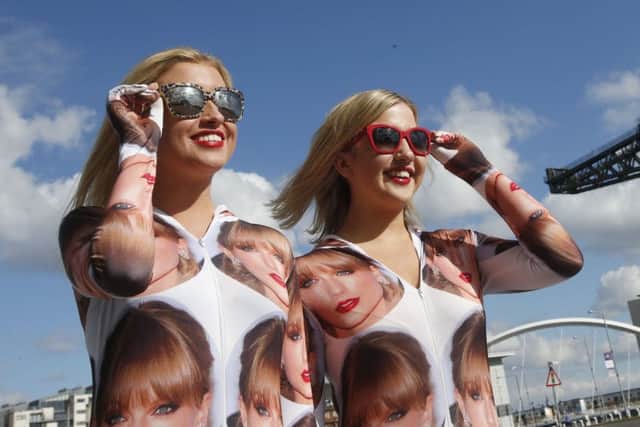 Fans Emma (left) and Lucy Robertson enjoy the sun ahead of Taylor Swift's sold-out gig. Picture: PA