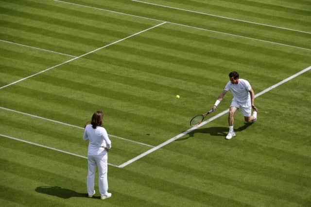 Andy Murray, watched by Amelie Mauresmo, during a practice at Wimbledon. Picture: Getty