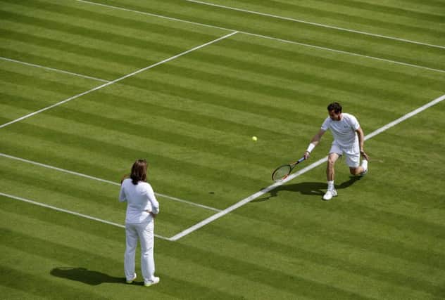 Andy Murray, watched by Amelie Mauresmo, during a practice at Wimbledon. Picture: Getty