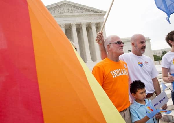 Rodney Moubray-Carrico and his husband Scott Moubray-Carrico stand with their son Lucas, 7, outside of the Supreme Court in Washington. Picture: AP