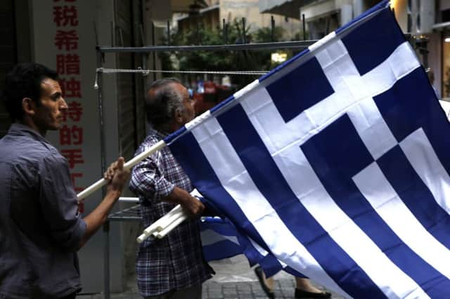A man sells Greek flags  could the country next reclaim the drachma? Picture: AP