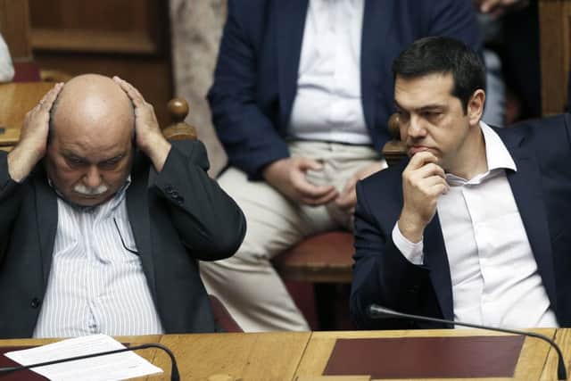 Prime minister Alexis Tsipras, right, and minister of interior and administrative reconstruction Nikos Voutsis at yesterdays emergency parliament session. Picture: Getty