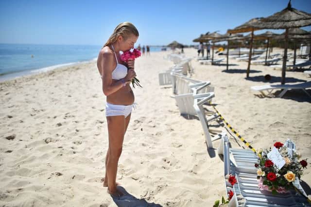 A woman lays flowers at the beach next to the Imperial Marhaba Hotel in Souuse. Picture: Getty