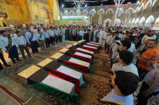Kuwait flags drape the coffins of people killed in the suicide bombing on a Shiite mosque. Picture AP