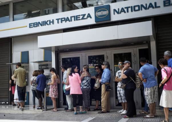 Greeks queue in front of the National Bank to use ATM to withdraw cash as Parliament holds an emergency session for the government's proposed referendum. Picture: Getty Images