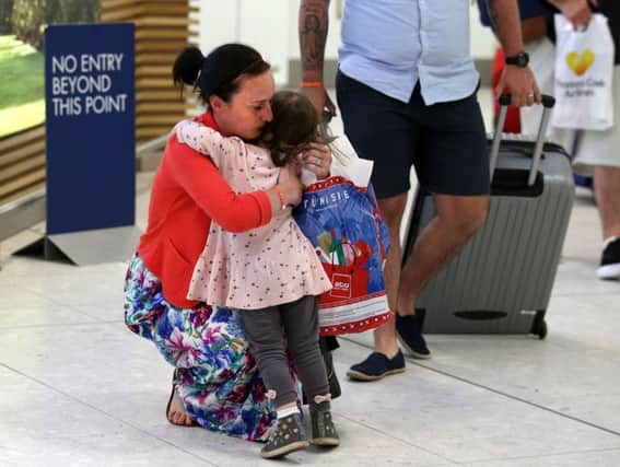 Helen and Darren Tait are greeted by their daughter as they arrive back at Glasgow from Tunisia. Picture: PA