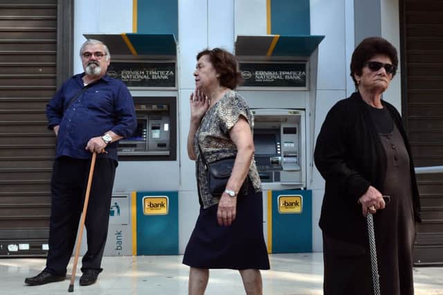 An elderly man stands by the National Bank of Greece's empty cash machines in Athens yesterday. Picture: Getty