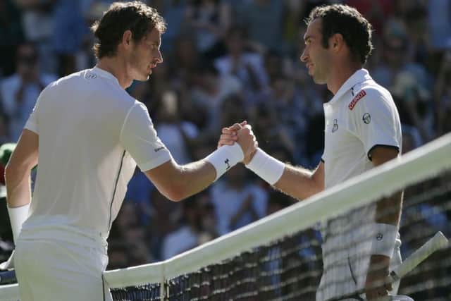 Andy Murray, left, shakes hands after defeating Mikhail Kukushkin of Kazakhstan. Picture: AP