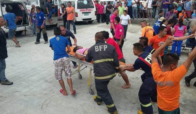 A survivor of a passenger ferry that capsized is pushed on a stretcher to a waiting ambulance after arriving at the pier in Ormoc City. Picture: Getty