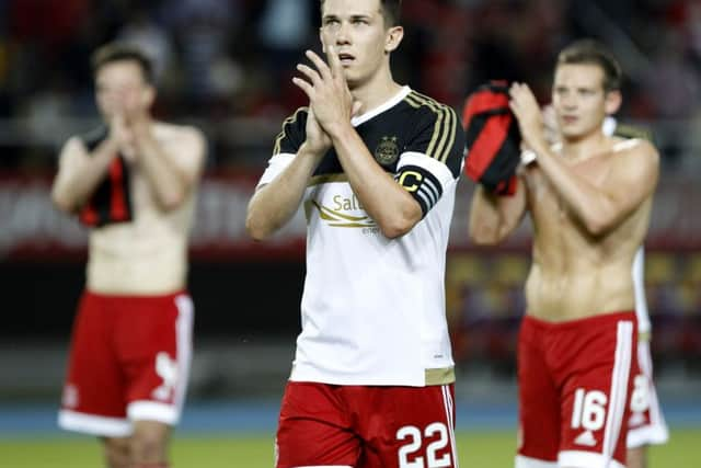 Dons skipper Jack with his teammates at full-time in Thursday night's Europa League clash. Picture: AP