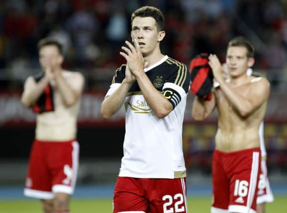 Dons skipper Jack with his teammates at full-time in Thursday night's Europa League clash. Picture: AP
