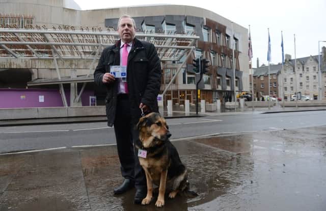 MSP Dennis Robertson, pictured with his guide dog , wants a ban on the electronic collars. Picture: Neil Hanna