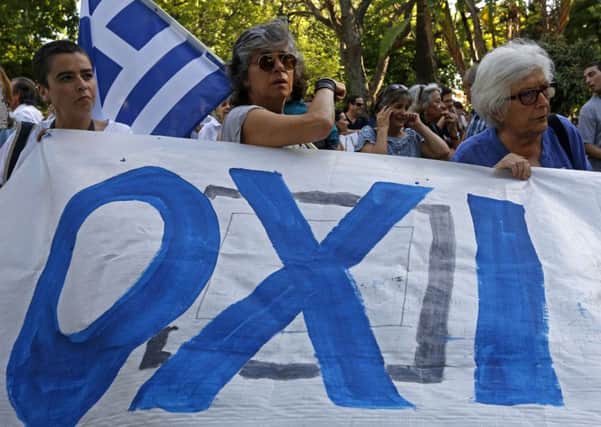 People hold a banner reading "OXI" (No in Greek) ahead of the vote. Picture: AFP/Getty
