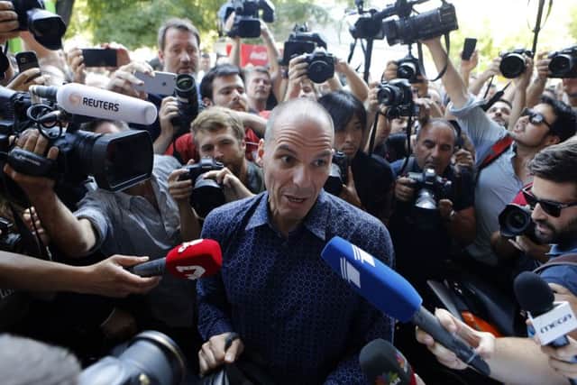 Outgoing Greek finance minister Yanis Varoufakis is surrounded by media as he tries to leave on his motorcycle after his resignation. Picture: AP