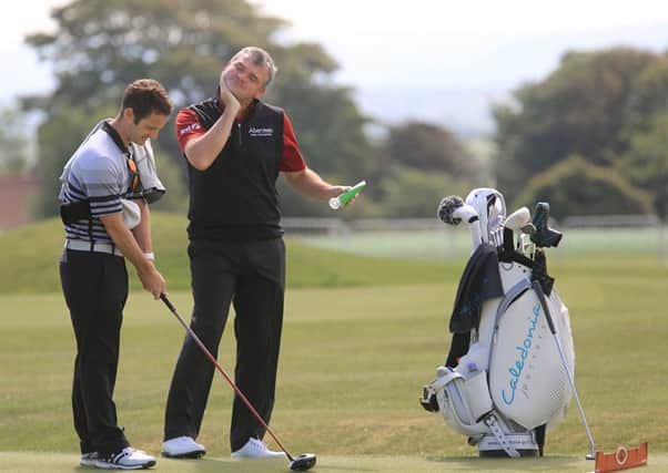 Paul Lawrie slaps on the sun screen before his practice round at Gullane yesterday. Picture: Gordon Fraser