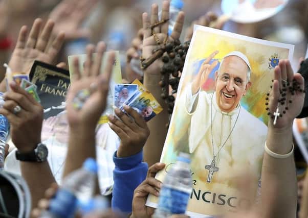 Pilgrims hold up their hands to be blessed by Pope Francis in Ecuador. Picture: AP