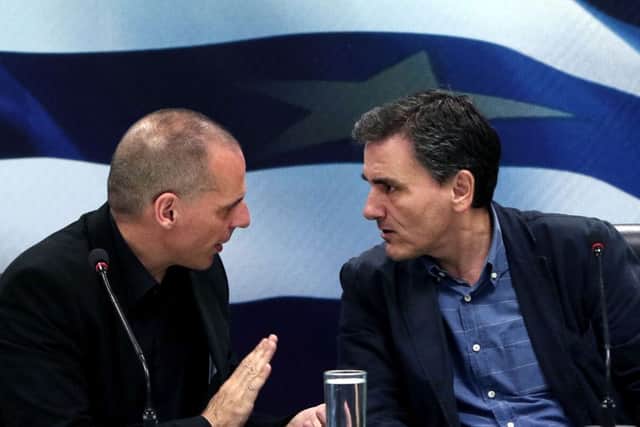 New finance minister Euclid Tsakalotos, right, with outgoing finance minister Yanis Varoufakis. Picture: AP