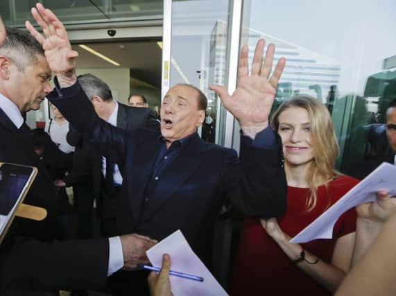 Silvio Berlusconi, with his daughter Barbara, waves to AC Milan fans outside the headquarters of the club, of which he is president. Picture: AP