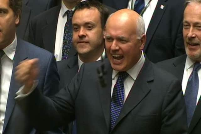 Works and Pensions Secretary Iain Duncan Smith punches the air as he listens to George Osborne deliver his Budget statement to the House of Commons. Picture: PA