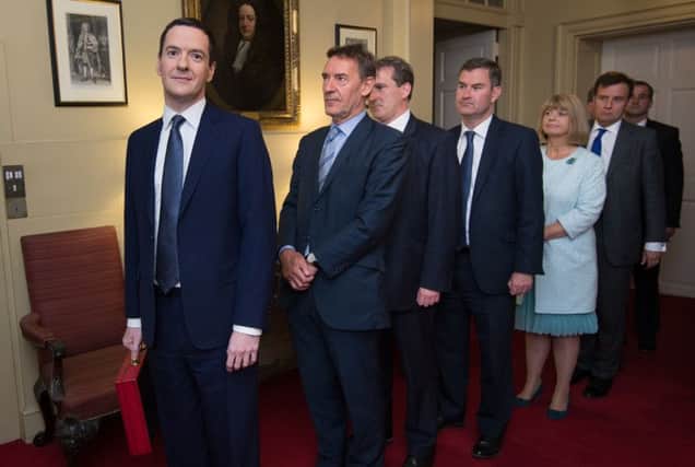 Chancellor George Osborne, left, prepares to lead his Treasury team out of Number 11 Downing Street yesterday. Picture: Getty