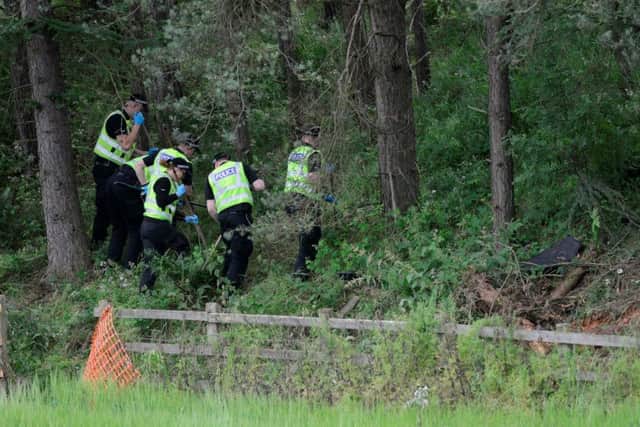 Police seach the verge where the couple where found in their car three days after they crashed. Picture: Hemedia