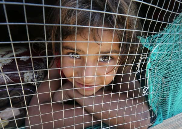 A Syrian refugee girl shelters at a refugee camp south of Beirut after her family fled to Lebanon. Picture:AFP/Getty Images
