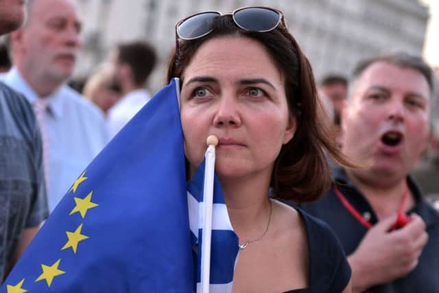 A pro-European Union protester holds EU and Greek flags during a demonstration in front of the Greek parliament in Athens. Picture: AFP/Getty Images