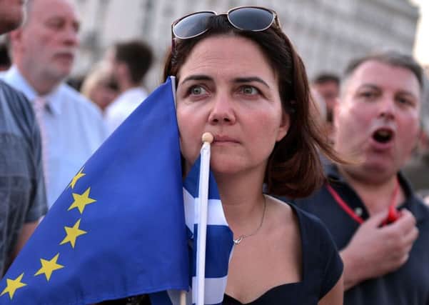 A pro-European Union protester holds EU and Greek flags during a demonstration in front of the Greek parliament in Athens. Picture: AFP/Getty Images