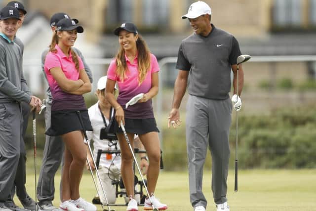 Tiger Woods waves to members of the public from the 17th green on the Old Course yesterday. Picture: AP