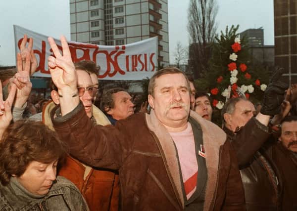 The leader of the banned Polish trade union Solidarity, Lech Walesa (centre) flashes a V-sign in 1988 in Gdansk. Picture: AFP/Getty
