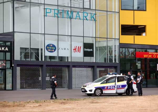 Police officers stand outside a suburban clothing store, in Villeneuve-la-Garenne, north of Paris. Picture: AP