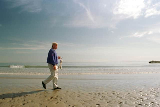 John Daly walking along the beach holding his Open trophy in 1995. Picture: Ian Rutherford