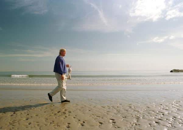 John Daly walking along the beach holding his Open trophy in 1995. Picture: Ian Rutherford