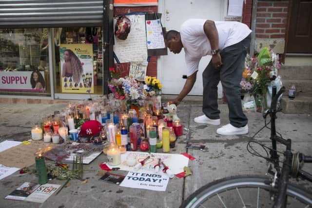 A mourner places a candle at a memorial for Eric Garner, who died while being arrested by New York City police. Picture: AP