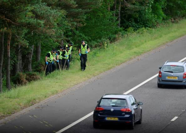 Officers comb the scene of the M9 crash. Picture: Hemedia