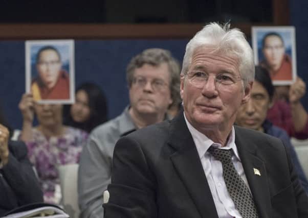 Tibetan rights activist and film star Richard Gere is surrounded by pictures of the lama. Picture: AFP/Getty